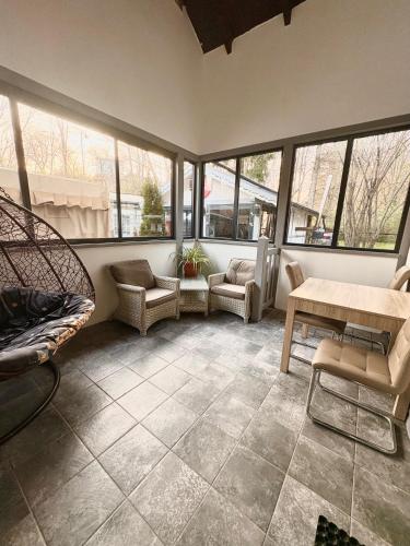 a living room with chairs and a table and windows at Willa Rybacka in Krynica Morska