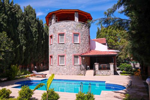 a building with a pool in front of a house at Villa Oasis Taşın Zarafeti,Modern Rahatlık in Dalaman