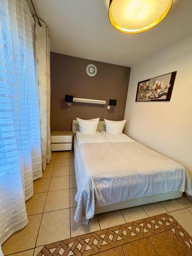 a bedroom with a bed and a clock on the wall at Willa Rybacka in Krynica Morska