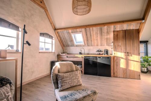 a kitchen with a couch and a chair in a room at B&B Country Suite Den Oord in Terwolde