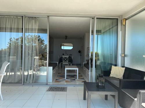 a living room with glass doors and a couch at Sunny Home Costa Plana-Monaco -Cap D'Ail in Cap d'Ail