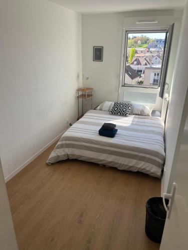 ein Schlafzimmer mit einem großen Bett mit einem großen Fenster in der Unterkunft Charme Citadin in Villemomble