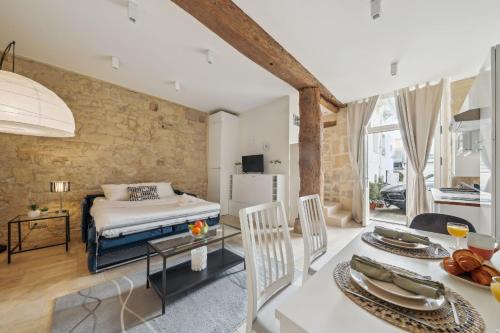 une chambre avec un lit et une salle à manger avec une table dans l'établissement BnBNova - Ile St Louis, à Paris