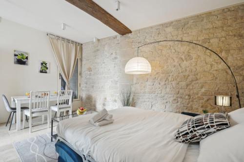 une chambre avec un grand lit et un mur en pierre dans l'établissement BnBNova - Ile St Louis, à Paris