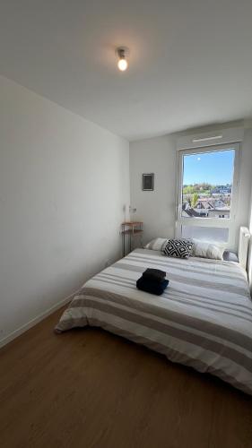 une chambre avec un grand lit avec une grande fenêtre dans l'établissement Charme Citadin, à Villemomble