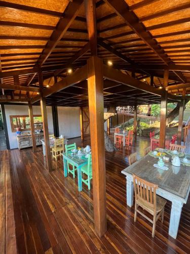 ein Esszimmer mit einem Tisch und Stühlen auf einem Holzboden in der Unterkunft Pousada Naiepe in Fernando de Noronha