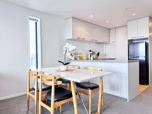 a kitchen with a white table and chairs at Amazing SeaView Central Stylish Near Aotea Square in Auckland