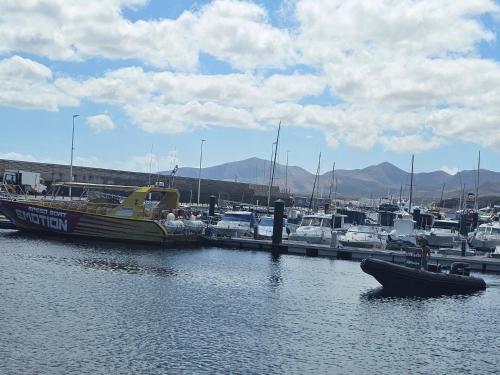 a boat is docked at a marina with other boats at Lanzarote Apartment Rental Harbour View in Tías