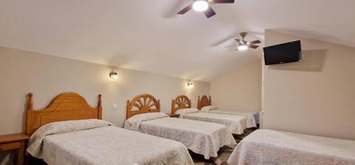 a hotel room with four beds and a flat screen tv at COSMA HOUSE in Hinojedo