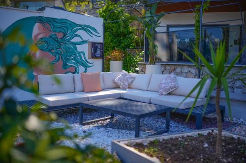a couch in a garden with a painting on the wall at Ramitos Hotel in Turunc