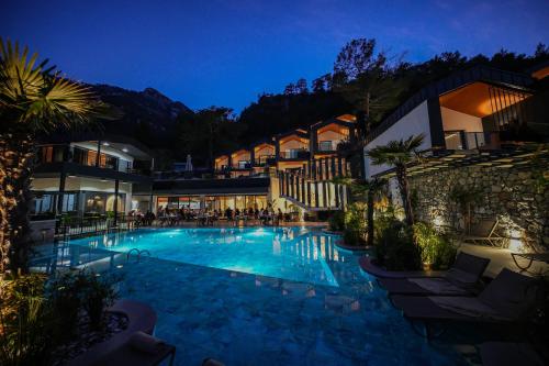 a hotel with a swimming pool at night at Ramitos Hotel in Turunc