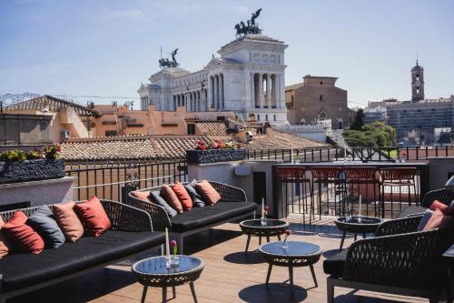 a patio with couches and tables on a roof at Otivm Hotel in Rome