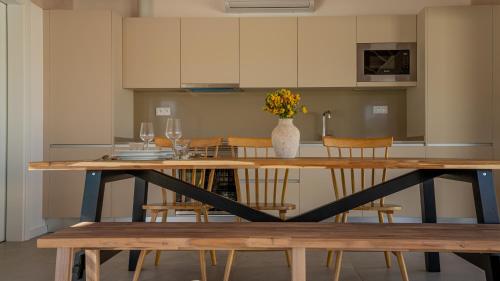 a kitchen with a table with chairs and a vase of flowers at Pestana Comporta Village Residences in Comporta