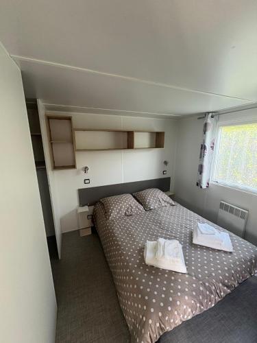 une chambre avec un lit avec deux serviettes dessus dans l'établissement Mobile Home XL Camping 5 étoiles, à Houlgate