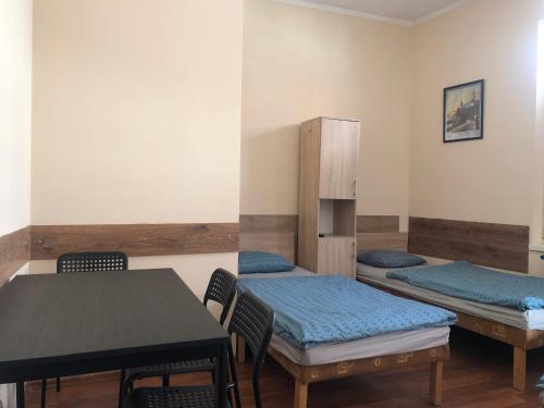 a room with two beds and a table and chairs at Noclegi Szóstka in Wałbrzych