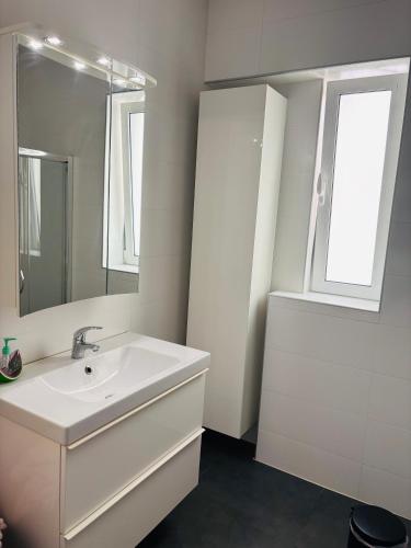 a white bathroom with a sink and a mirror at ZASE Luxury Homes in Xylokastro