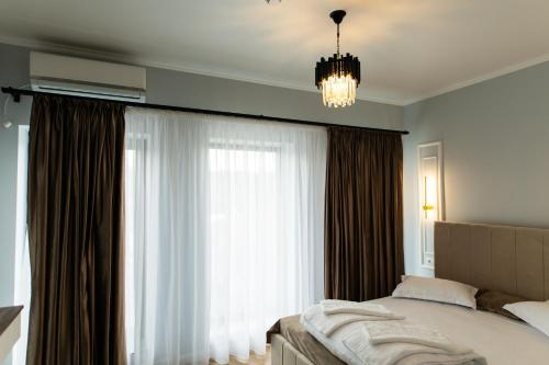 a bedroom with a bed and a large window at TisArt Hotel in Tismana