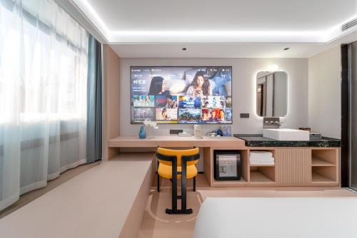 a bathroom with a desk and a television in a room at Liuxiang Shangcui Hotel in Suzhou