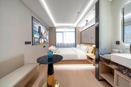a hotel room with a bed and a table at Liuxiang Shangcui Hotel in Suzhou