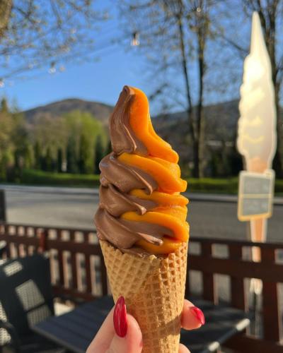 a person holding an ice cream cone with chocolate and caramel at Hotel U Kociana in Trojanovice