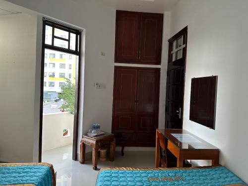 a room with a bed and a desk and a window at Anh Minh HOTEL in Thôn Mỹ Phước