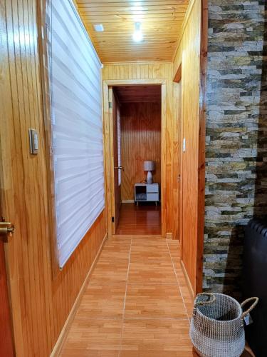 a hallway with a stone wall and wooden floors and a room at Casa de Campo a 15km de Coyhaique in Coihaique