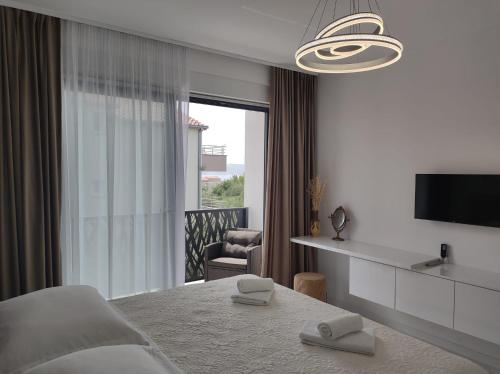 a bedroom with a bed and a tv and a window at Villa Lauvi, Free Fiat 500 Cabriolet, Scooters , PS5 in Kaštela