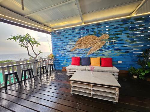a room with a blue wall with pillows and a table at 舞浪海景旅店 in Xiaoliuqiu