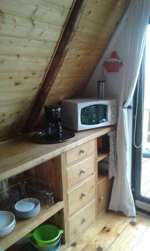une cuisine avec un four micro-ondes sur un comptoir en bois dans l'établissement CHALET du THOR, à Taussac