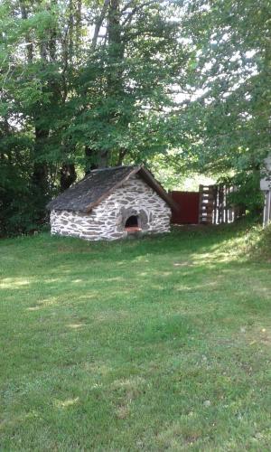 une petite maison en pierre dans un champ d'herbe dans l'établissement CHALET du THOR, à Taussac