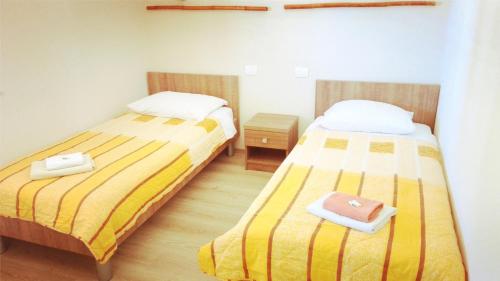two beds in a small room with at Pansion Eden in Međugorje