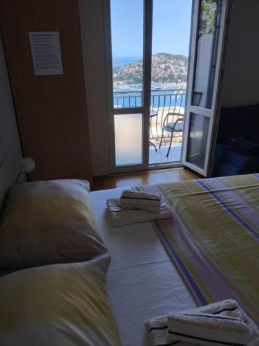 Un dormitorio con una cama y vista a un balcón. en Pansion Panorama Dubrovnik, en Dubrovnik