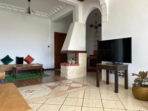 a living room with a flat screen tv and a couch at Blue pearl Mogador in Essaouira