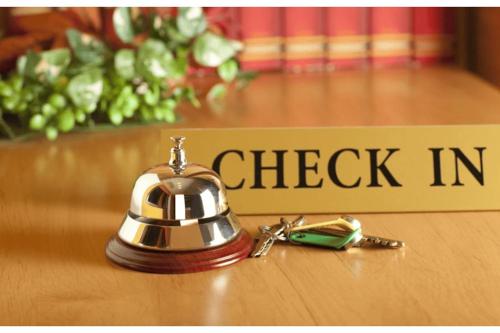 a bell sitting on a table next to a check in sign at Uday Homestay in Rāmpur