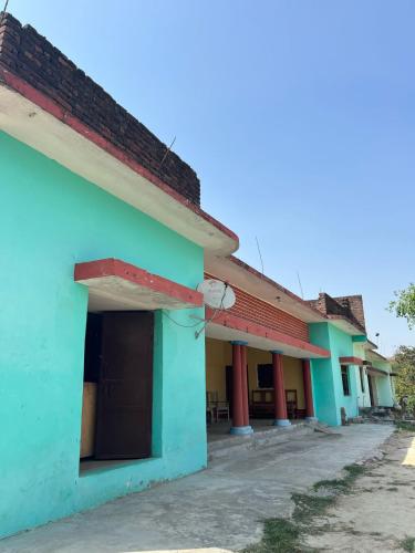 a row of houses with green and blue at Uday Homestay in Rāmpur