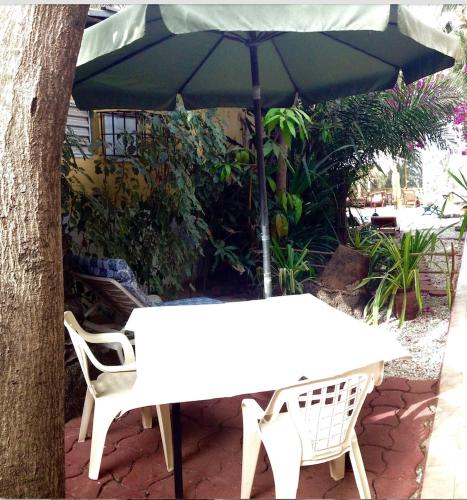 a white table and chair under an umbrella at ECOLODGE SAFARI in Cap Skirring