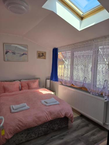 a bedroom with a bed with two towels on it at ELDI House in Făgăraş