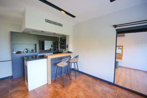 a kitchen with a counter and stools in a room at Ramitos Hotel in Turunc