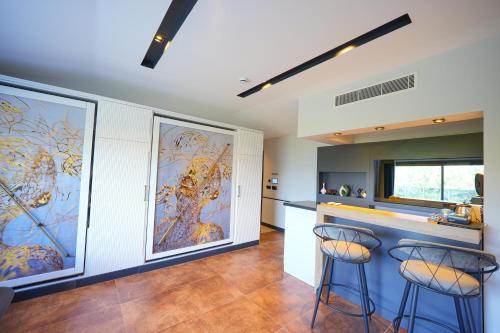 a kitchen with two bar stools and a large mural at Ramitos Hotel in Turunc