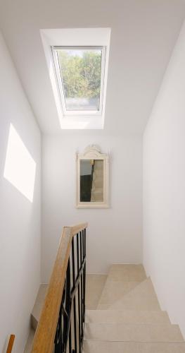 a skylight in the ceiling of a room with stairs at Adela & Ľudovít - 2 charizmatické apartmány v centre Modry nielen pre svadobných hostí in Modra