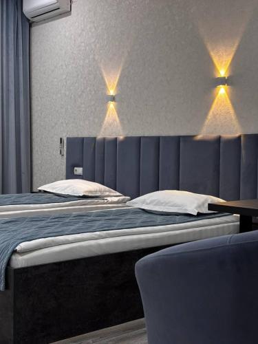 a bedroom with a large bed with lights above it at JETISY COMPLEX in Taraz