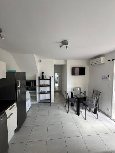 une cuisine et une salle à manger avec une table et des chaises dans l'établissement Villa bord de mer Vias plage, à Vias