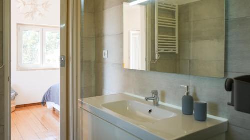 un baño con lavabo y espejo en Zéfiro Ericeira, en Ericeira