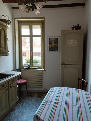 - une cuisine avec un lit, un évier et une fenêtre dans l'établissement Les racines, à Haspres