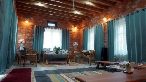 a living room with blue curtains and a table and chairs at Gauraaj The Village Living in Chutwāpīpal