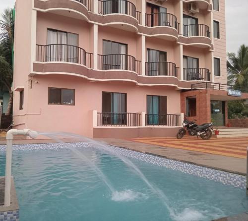 a villa with a swimming pool in front of a building at SV Inns Sea Pearl in Devgarh