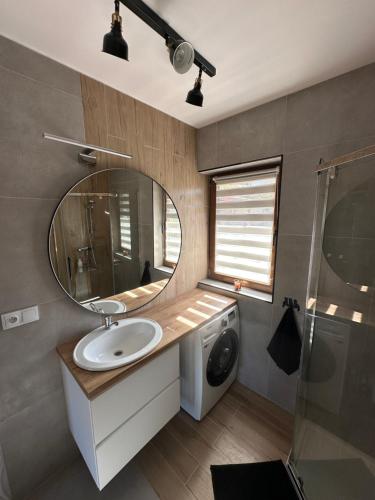 a bathroom with a sink and a mirror and a washing machine at Przystanek Zawóz in Zawóz