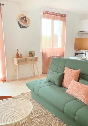 un salon avec un canapé vert et une table dans l'établissement Le Lodge, à Fougères