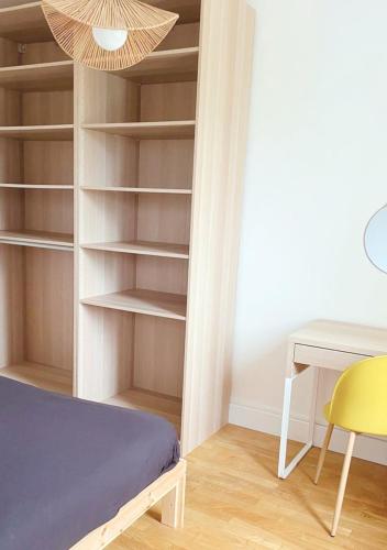 a room with a bed and a table and a desk at Le Lodge in Fougères