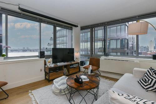 a living room with a television and large windows at Modern Times Square 1 BR Retreat in New York